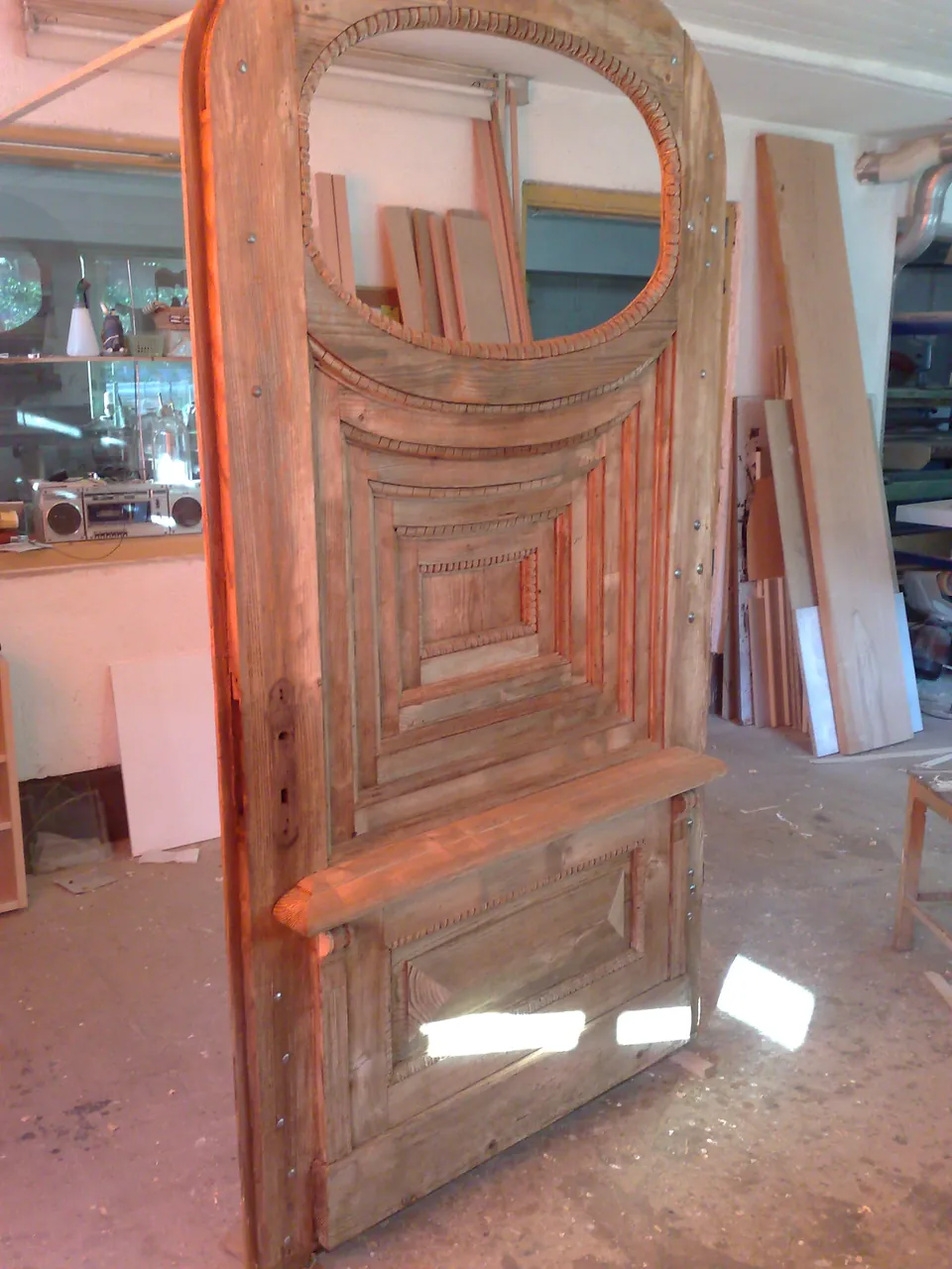 Alte Kassettentür mit Rundbogen und Ovalfenster bei der Restaurierung