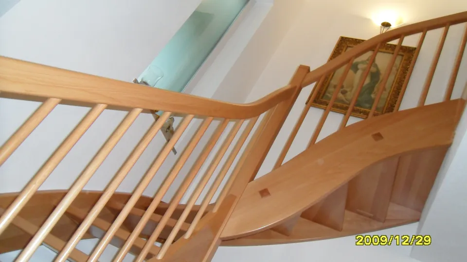Geschwungene Holzstiege mit Rundstabgeländer, Blick von unten