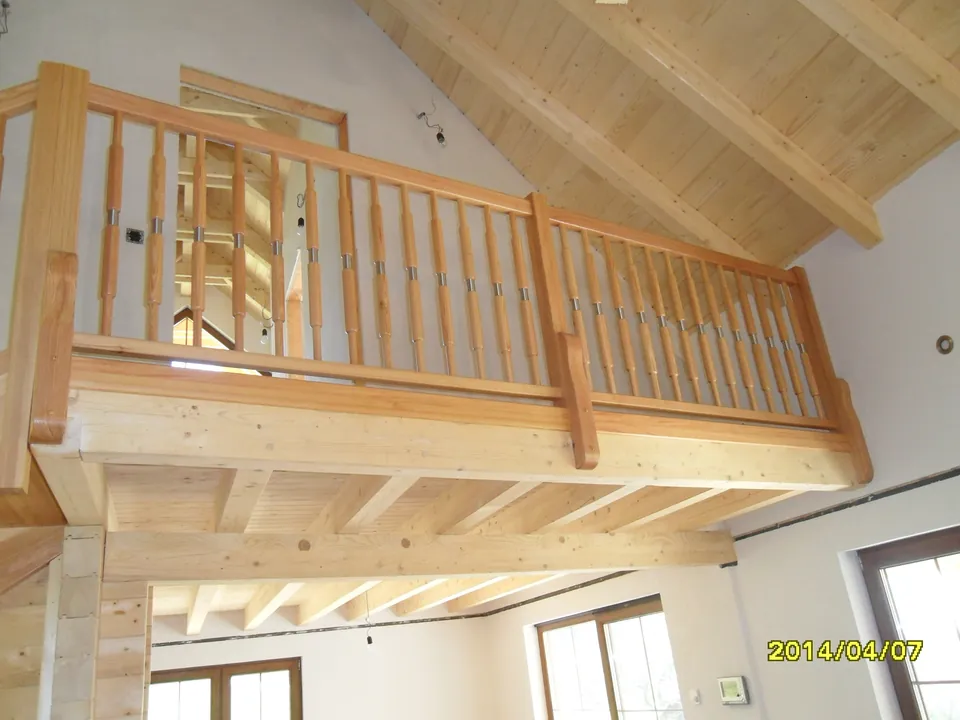 Galerie mit gedrechseltem Holzgeländer unter sichtbarem Dachstuhl