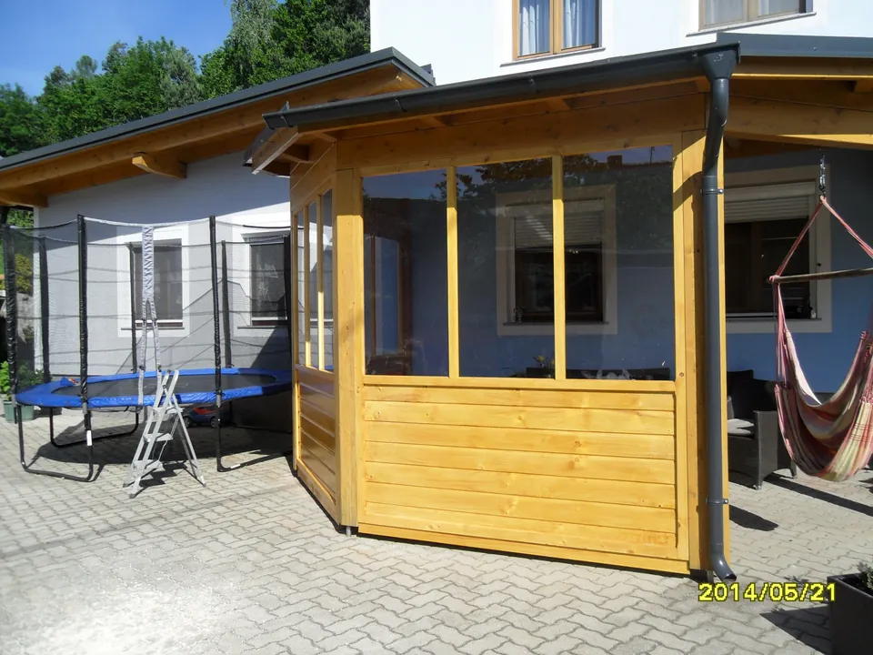 Verglaster Holzpavillon als Terrassenanbau an einem Wohnhaus