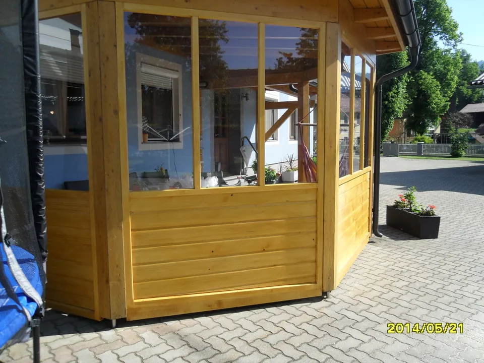 Holzverkleideter Wintergarten mit großen Glasflächen, Seitenansicht