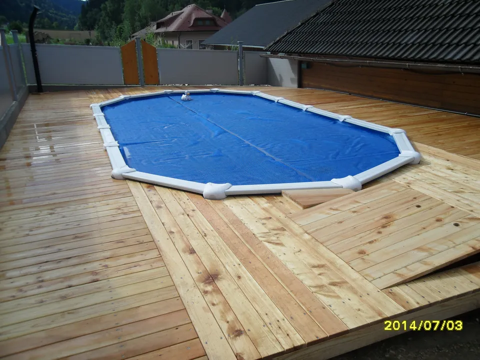 Holzterrasse aus Lärchendielen rund um einen ovalen Aufstellpool