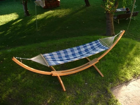 Hängemattengestell aus gebogenem Holz mit Stoffhängematte im Garten
